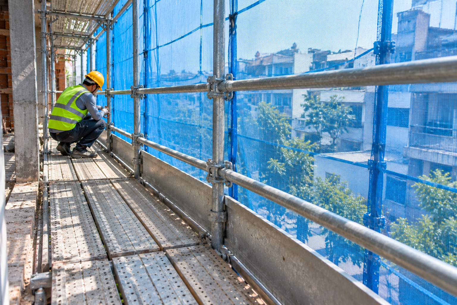 Lưới bao che xanh căng ngoài giàn giáo công trình đang thi công
